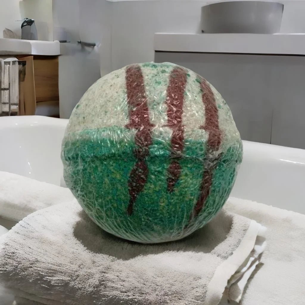 Angels and Saints Bath Bomb - MG Bath Products Bath bomb that is wrapped in plastic and has a white colored top, green colored bottom, and three brown stripes.Bath Bomb