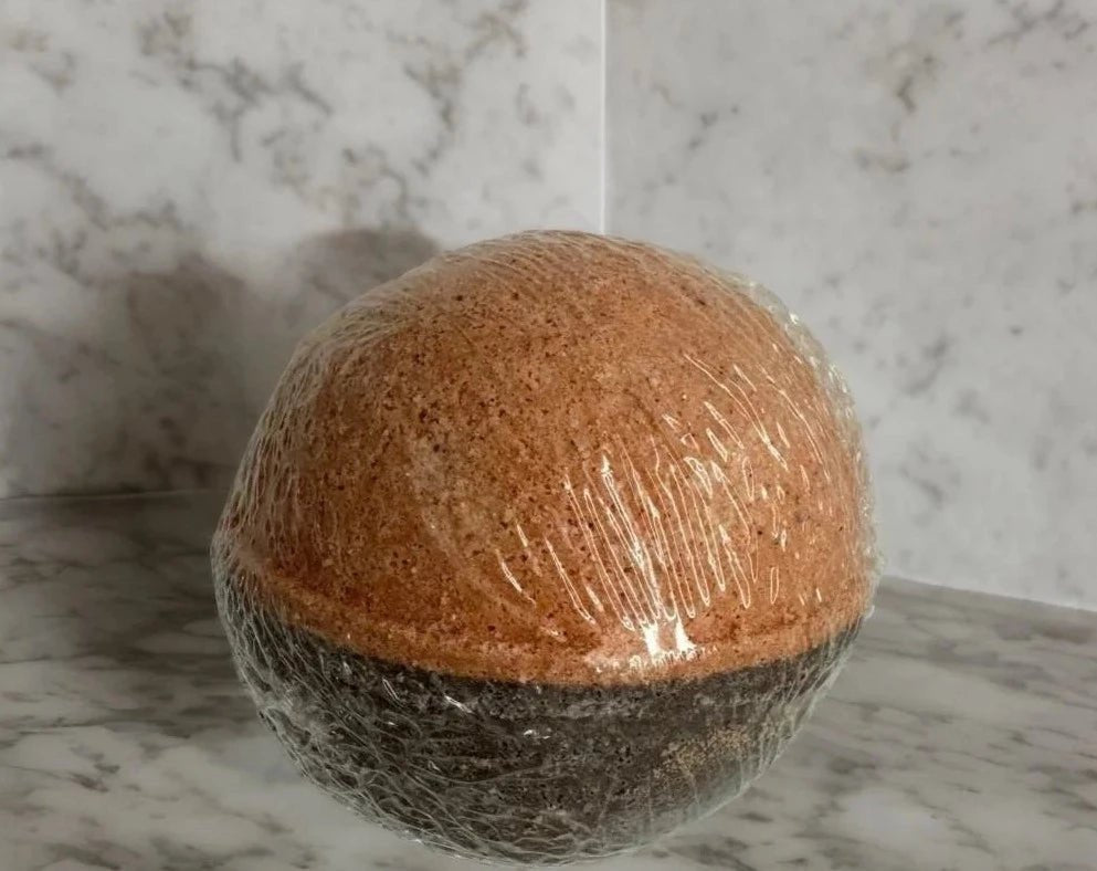 Chocolate Orange Bath Bomb - MG Bath Products Bath bomb that has a orange colored top and a brown colored bottom that is wrapped in plastic.Bath Bomb