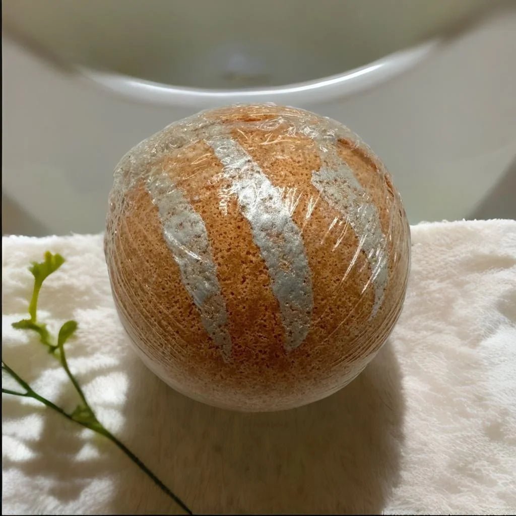 Orange Vanilla Bath Bomb - MG Bath Products Orange colored bath bomb with three silver stripes wrapped in plastic.Bath Bomb