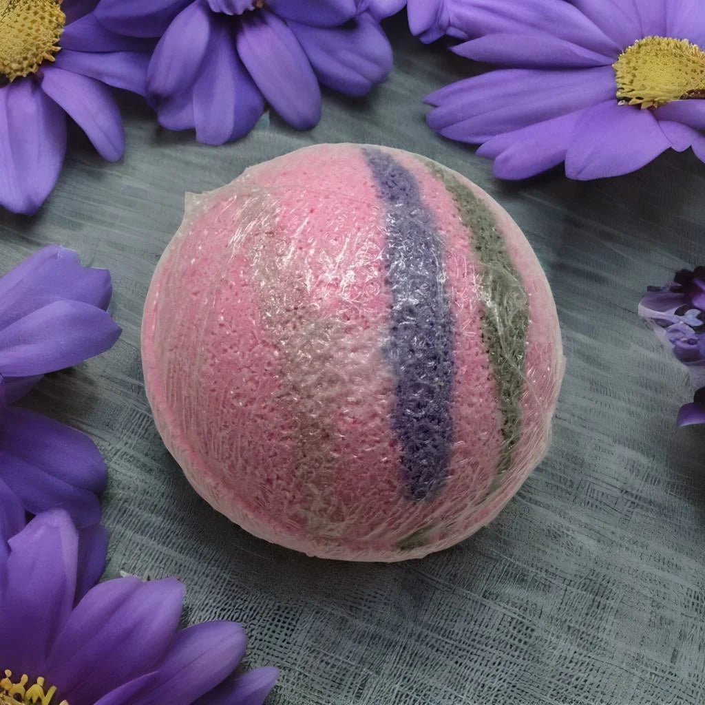 Royal Gardens Bath Bomb - MG Bath Products Pink colored bath bomb with a purple stripe and a green stripe wrapped in plastic surrounded by purple flowers.Bath Bomb